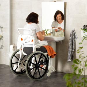 Etac Clean -suihkutuoli, kelattava 24" - nainen peilin edessä