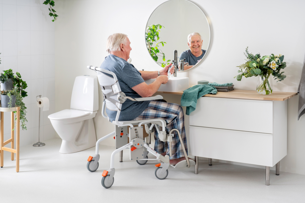 Etac Swift Mobil-2 - suihku ja -wc-tuoli XL - mies peilin edessä