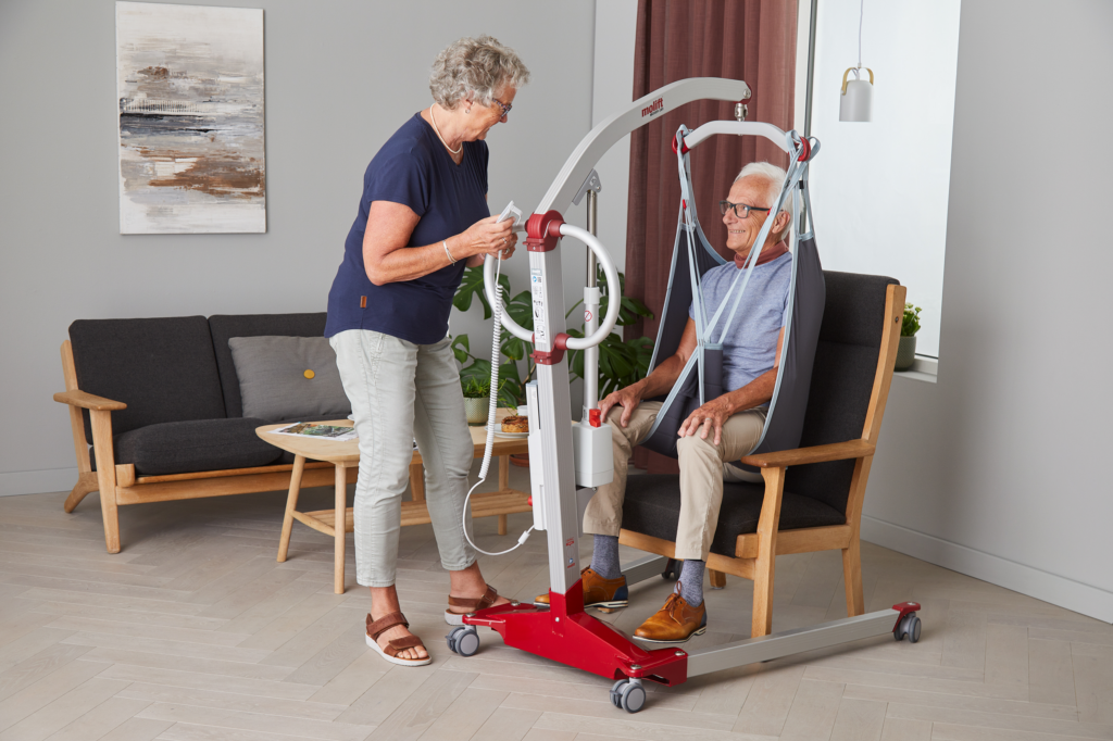 Molift Mover 180 -henkilönostolaite - EvoSling MB Padded -nostoliina - mies ja nainen olohuoneessa