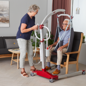 Molift Mover 180 -henkilönostolaite - EvoSling MB Padded -nostoliina - mies ja nainen olohuoneessa
